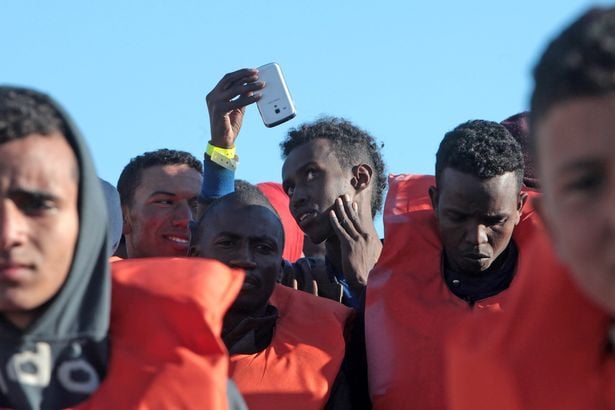 Migrants and refugees disembark from a Maltese coast guard patrol vessel