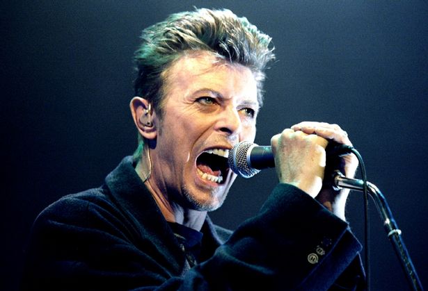 British Pop Star David Bowie screams into the microphone as he performs on stage during his concert