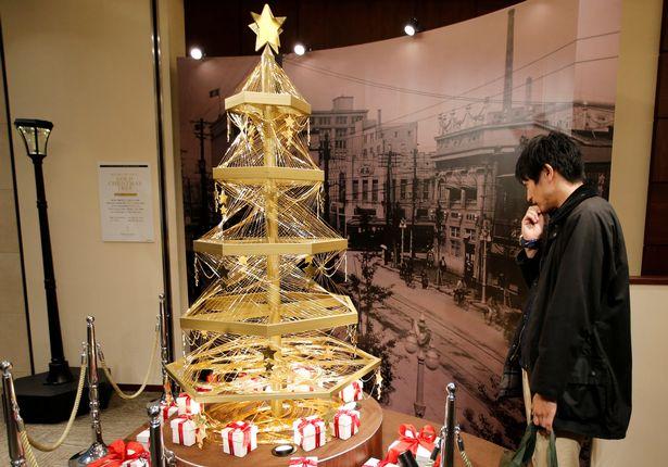 A gold Christmas tree decorated with 19 kilograms 418 lbs of pure gold wires is displayed for sa