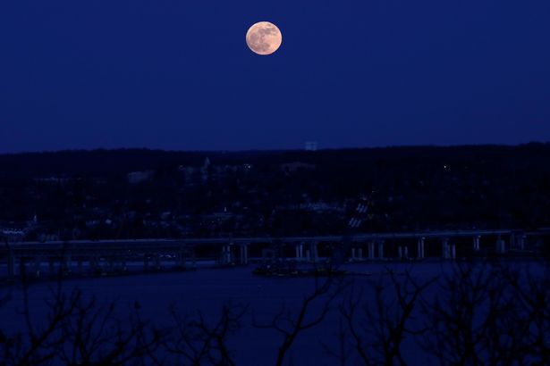 A supermoon full moon is seen above the Hudson River and the Mario M Cuomo Bridge from Nyac